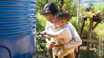 A woman with a child washing their hands