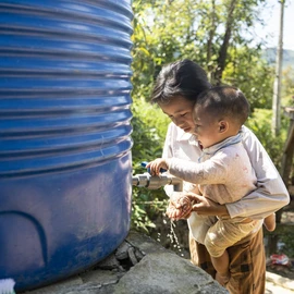 A woman with a child washing their hands