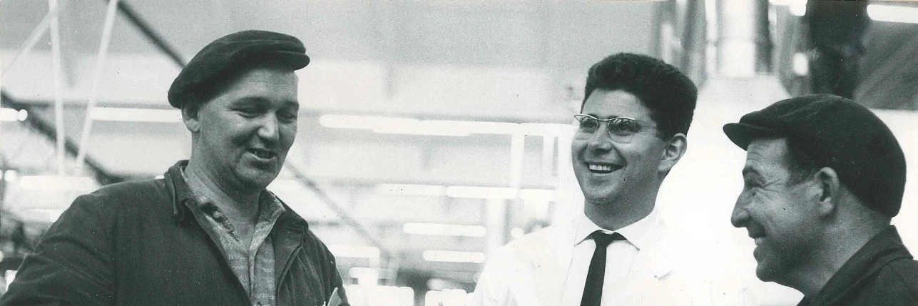 Heinz Dürr laughing while talking to two employees